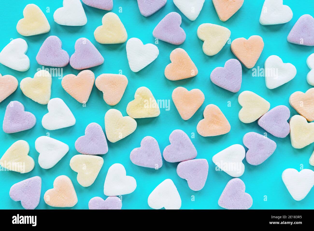 Bunte Zuckerrüben in Herzform auf blauem Hintergrund. Kreatives Urlaubskonzept der Liebe. Valentinstag. Stockfoto