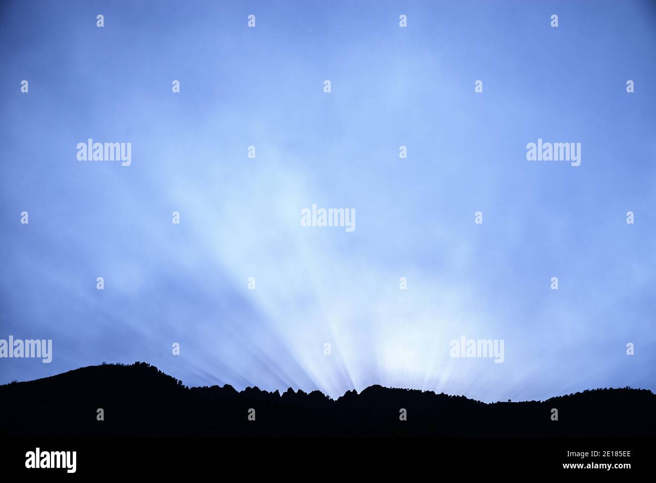Sonnenstrahlen erhellen Wildfire Rauch über einem zerklüfteten bergrücken der sierra Stockfoto