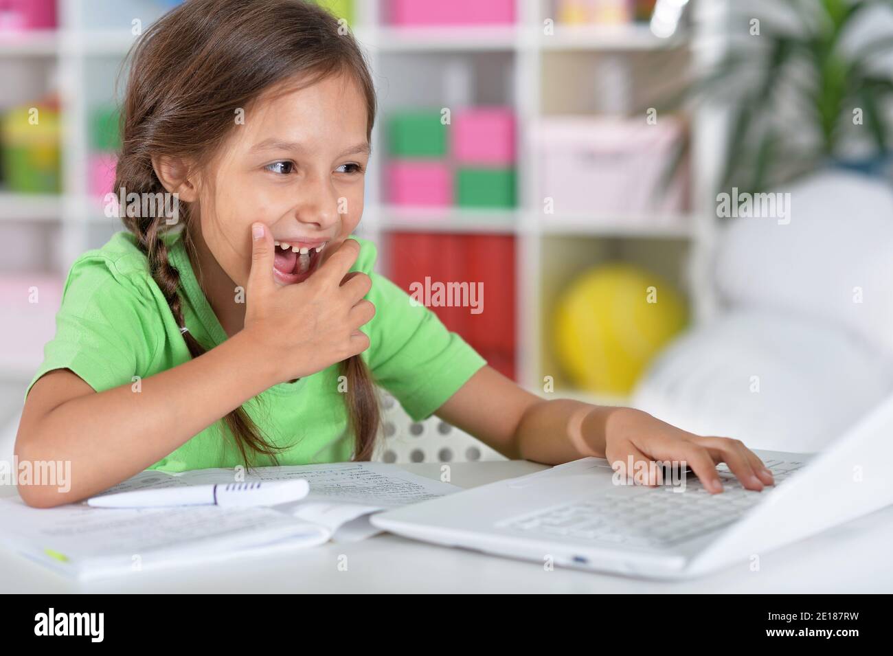 Portrait von konzentrierten kleinen Mädchen mit Laptop studieren Stockfoto