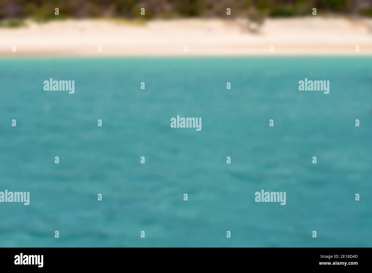 Verschwommenes Bild von blauem Wasser im Ozean und einem Strand - verschwommener Hintergrund Urlaub Thema Stockfoto
