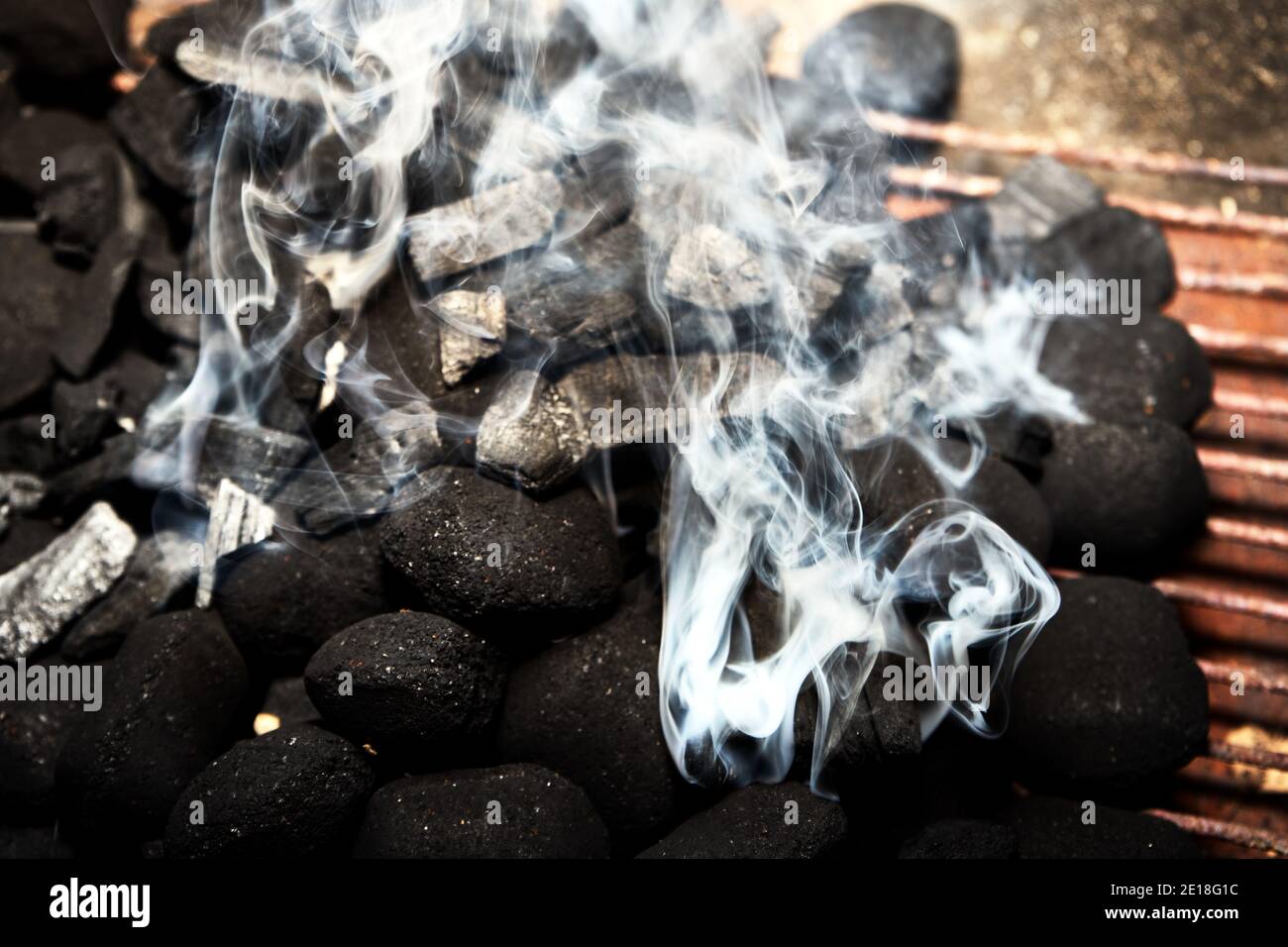Rauchentwicklung bei der Beleuchtung des BBQ Grill mit Holzkohle und Briketts gefüllt. Stockfoto