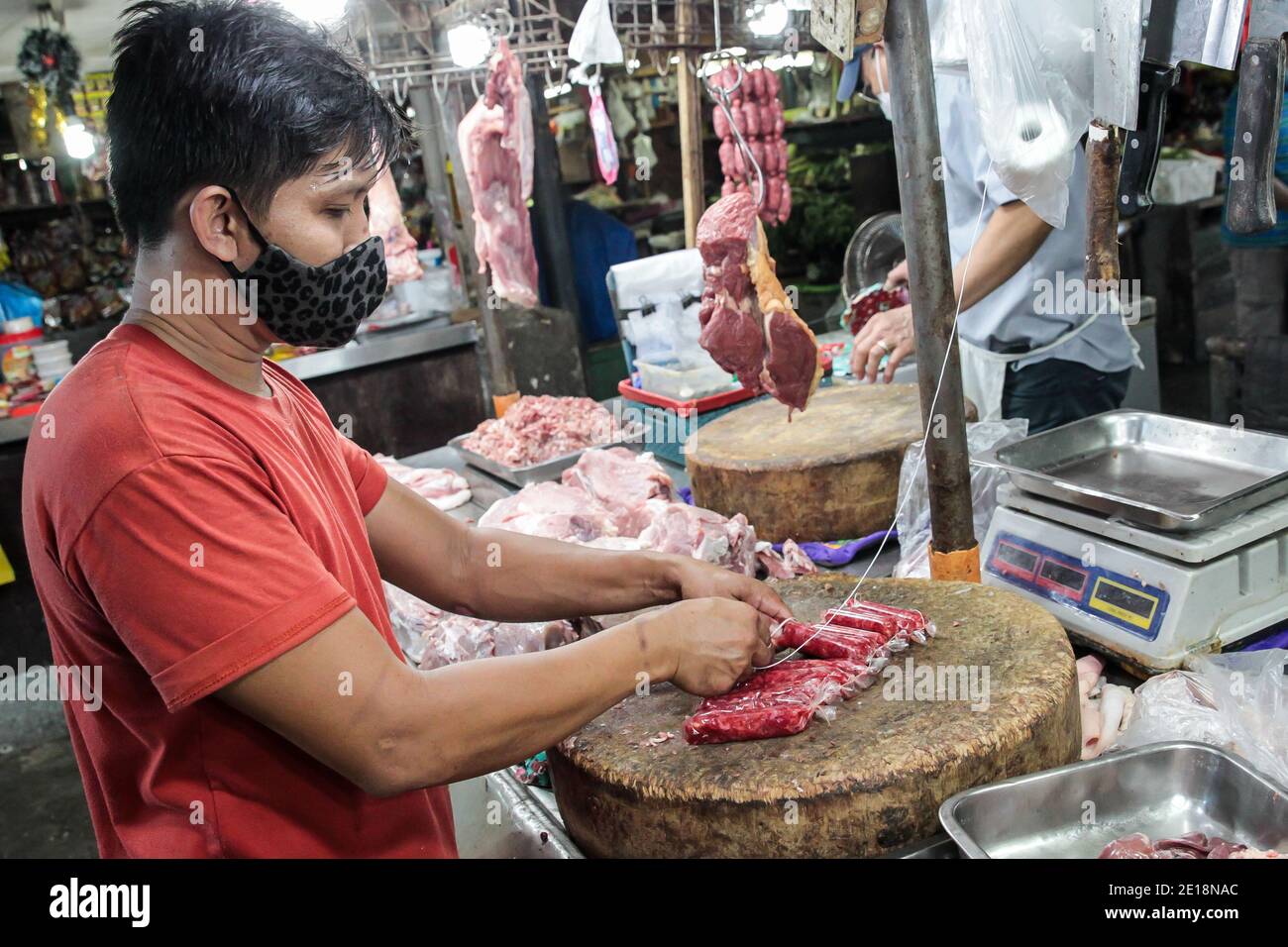 Manila, Philippinen. Januar 2021. Ein Verkäufer, der eine Maske trägt, macht Würste auf einem Markt in Manila, Philippinen, 5. Januar 2021. Die Inflation auf den Philippinen stieg im Vergleich zum Vorjahr im Dezember 2020 auf 3.5 Prozent, ein Anstieg von 3.3 Prozent im November 2020, getrieben von einem Anstieg der Nahrungsmittel und alkoholfreien Getränke, teilte die Philippine Statistics Authority (PSA) am Dienstag mit. PSA-Chef Dennis Mapa sagte einer virtuellen Pressekonferenz, dass dies die höchste Inflation seit März 2019 sei. Quelle: Rouelle Umali/Xinhua/Alamy Live News Stockfoto