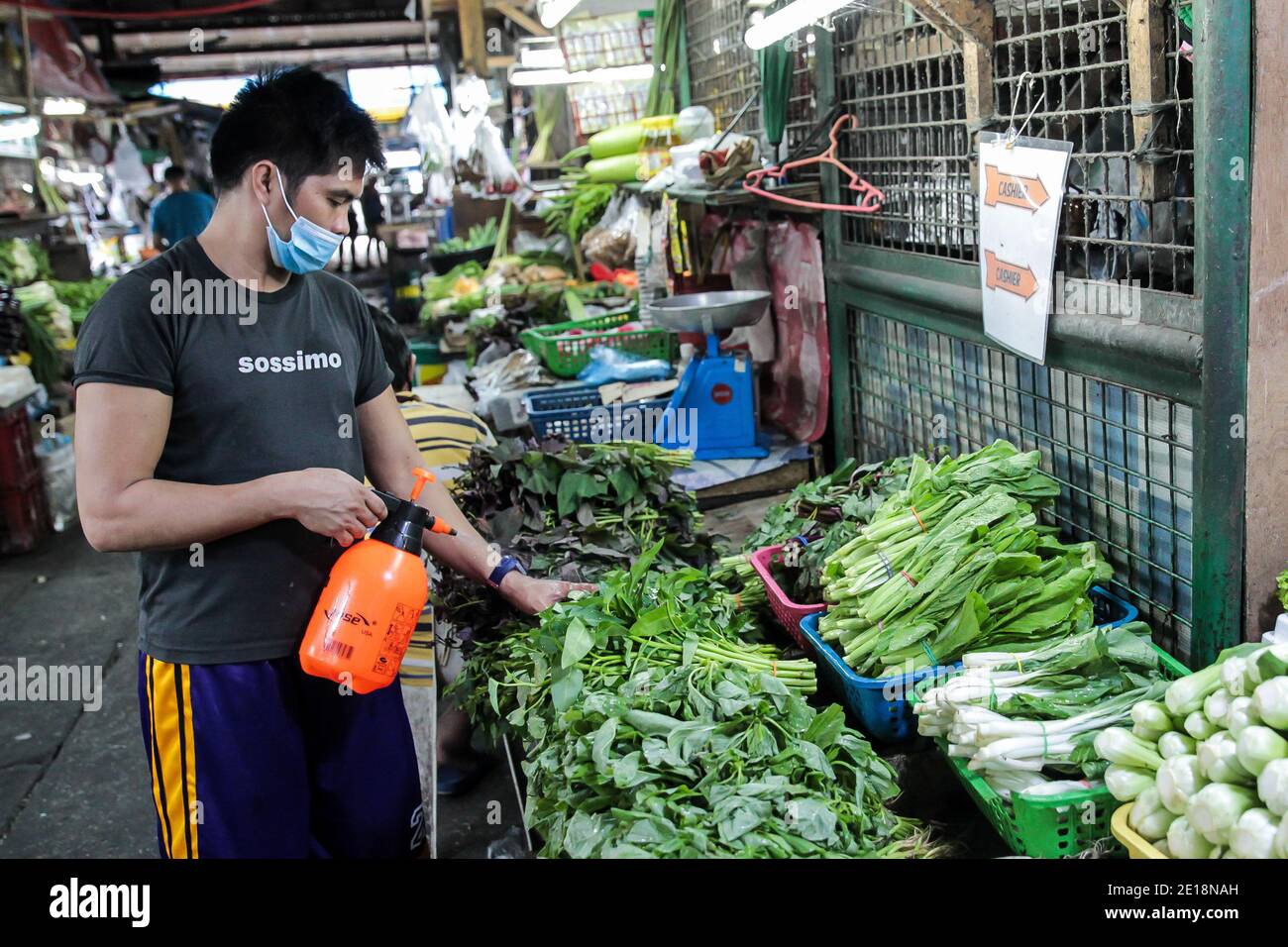 Manila, Philippinen. Januar 2021. Ein Verkäufer trägt eine Maske befeuchtet Gemüse, das auf einem Markt in Manila, Philippinen, 5. Januar 2021 verkauft wird. Die Inflation auf den Philippinen stieg im Vergleich zum Vorjahr im Dezember 2020 auf 3.5 Prozent, ein Anstieg von 3.3 Prozent im November 2020, getrieben von einem Anstieg der Nahrungsmittel und alkoholfreien Getränke, teilte die Philippine Statistics Authority (PSA) am Dienstag mit. PSA-Chef Dennis Mapa sagte einer virtuellen Pressekonferenz, dass dies die höchste Inflation seit März 2019 sei. Quelle: Rouelle Umali/Xinhua/Alamy Live News Stockfoto