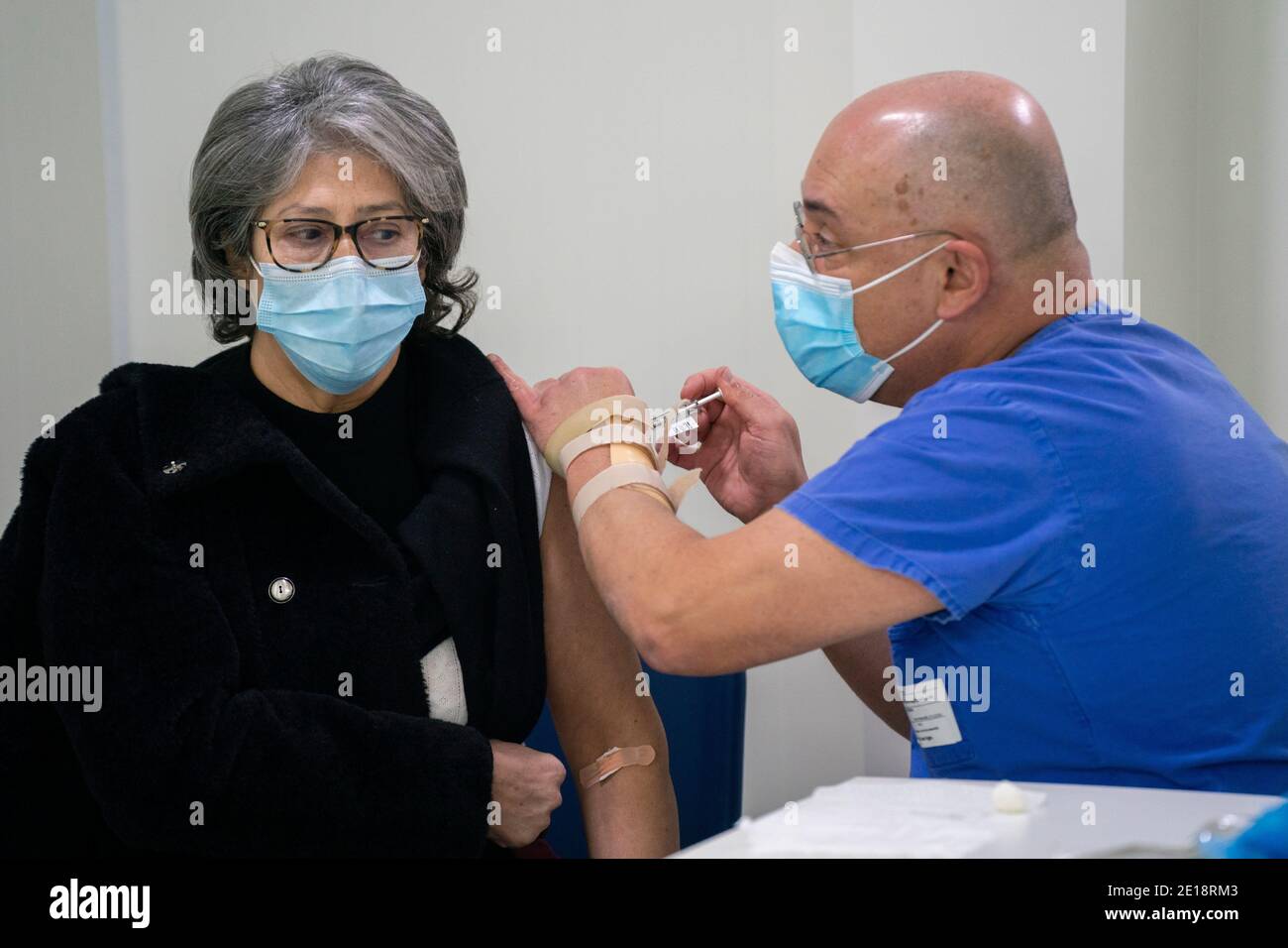 Krankenschwester, die einen Mann mit dem Impfstoff Pfizer-BioNTech Covid 19 impft Stockfoto