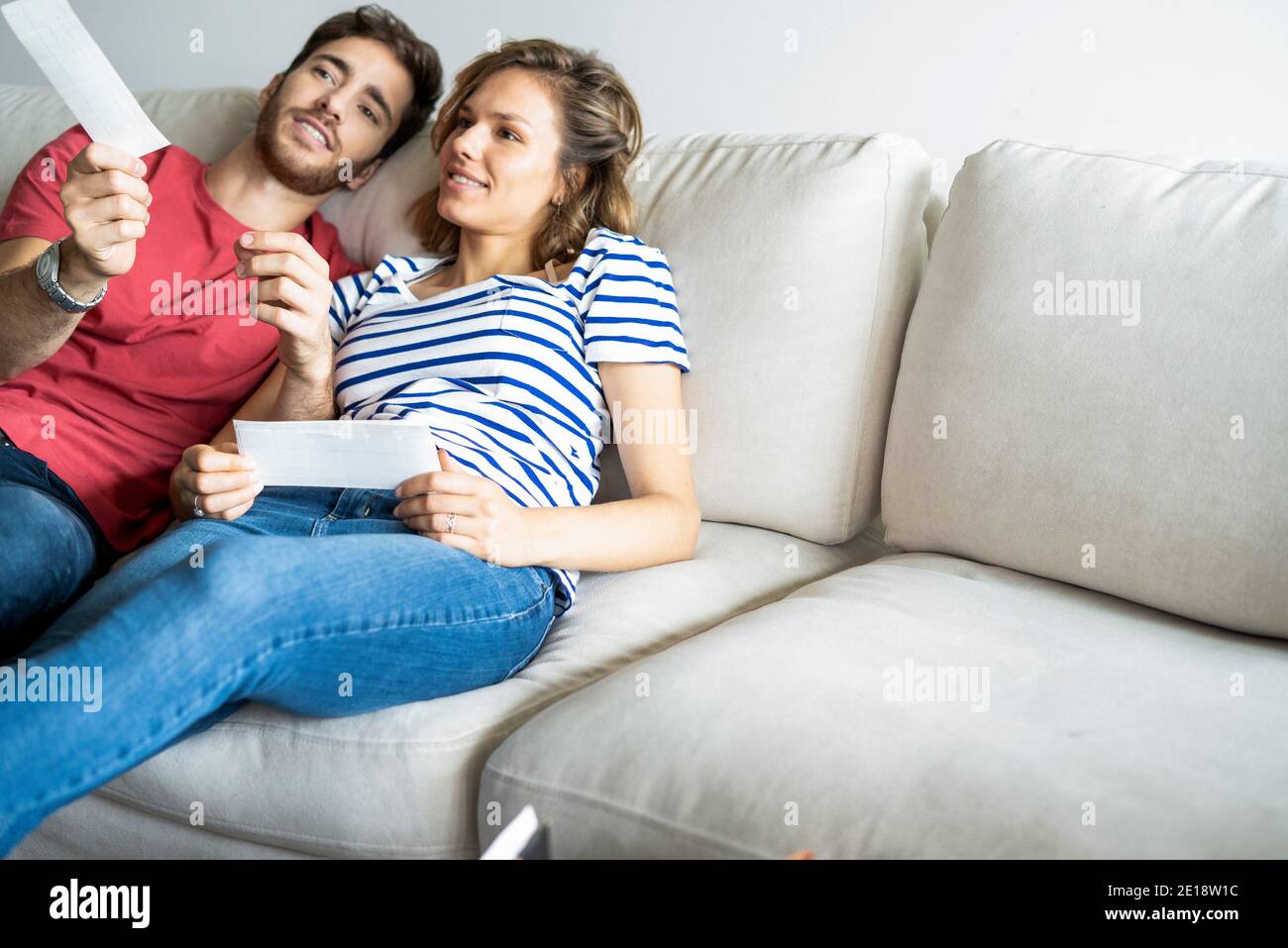 Junges Paar im Gespräch miteinander auf dem Sofa in ihrer Neues Haus Stockfoto
