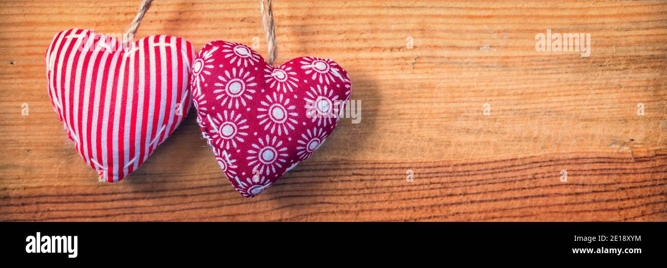 Zwei Herzen auf rotem Stoff alte Panoramablick Holz Hintergrund, Valentines Tag Web Banner Stockfoto