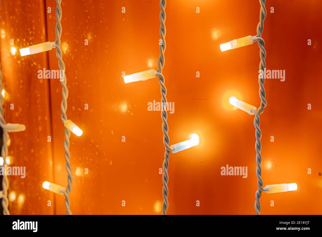 Gelb-orange Lichter von Girlande-Lampen auf dem Draht Stockfoto