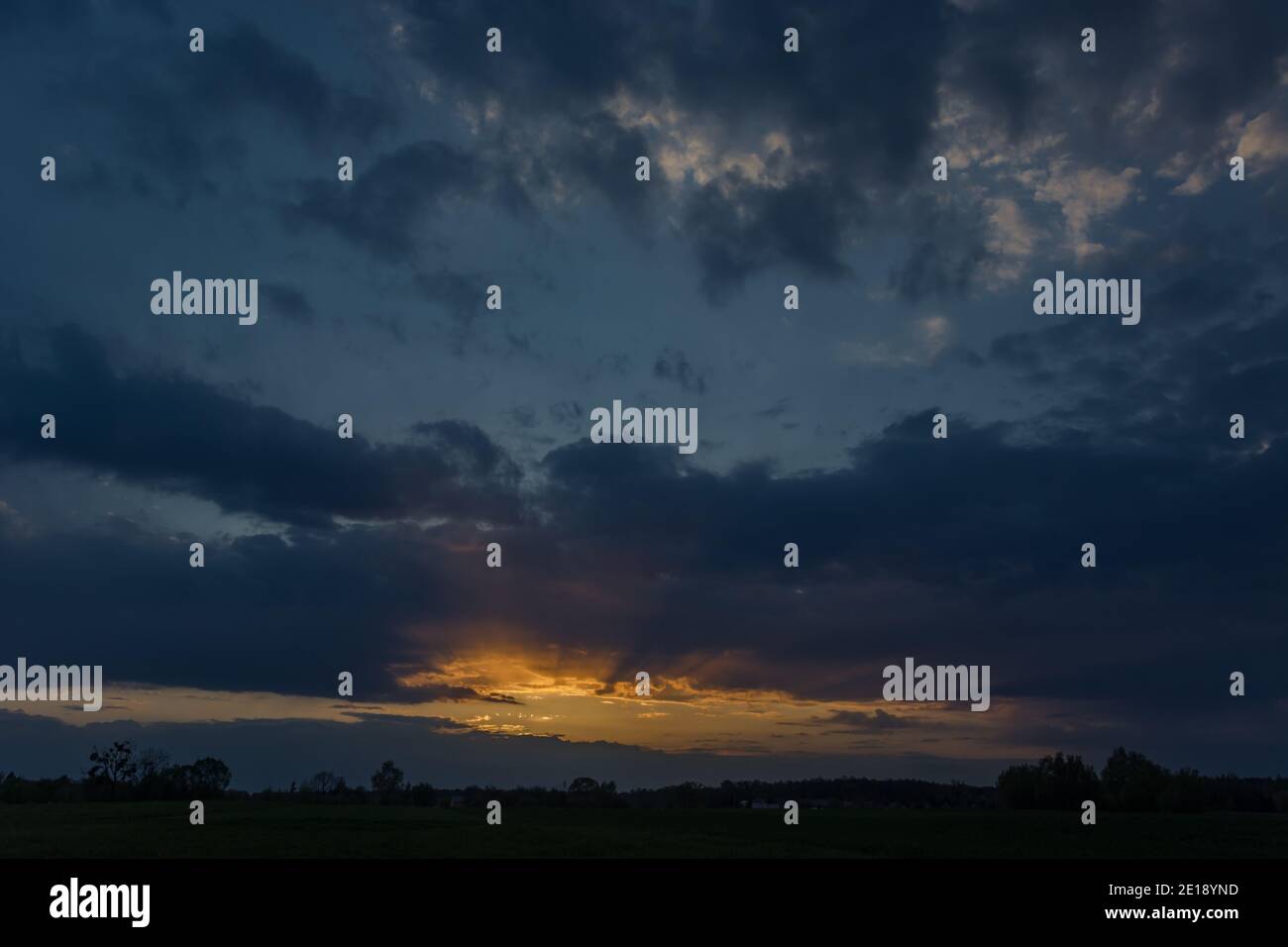 Glühen und Sonnenstrahlen in den Abendwolken Stockfoto