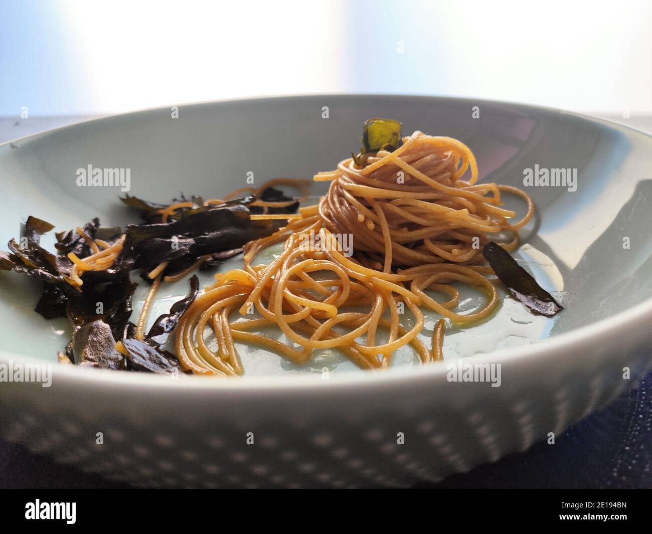 Kombu Seetang Spaghetti in einem blauen Teller Stockfoto