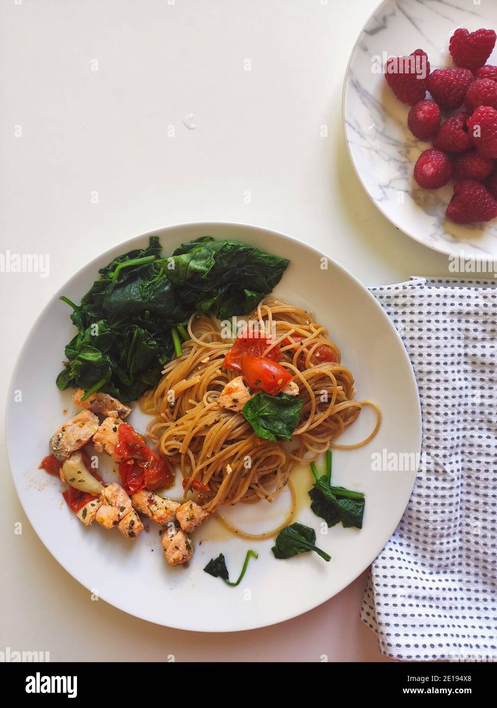 Spaghetti mit Spinat und Lachs in einer weißen Schüssel Stockfoto