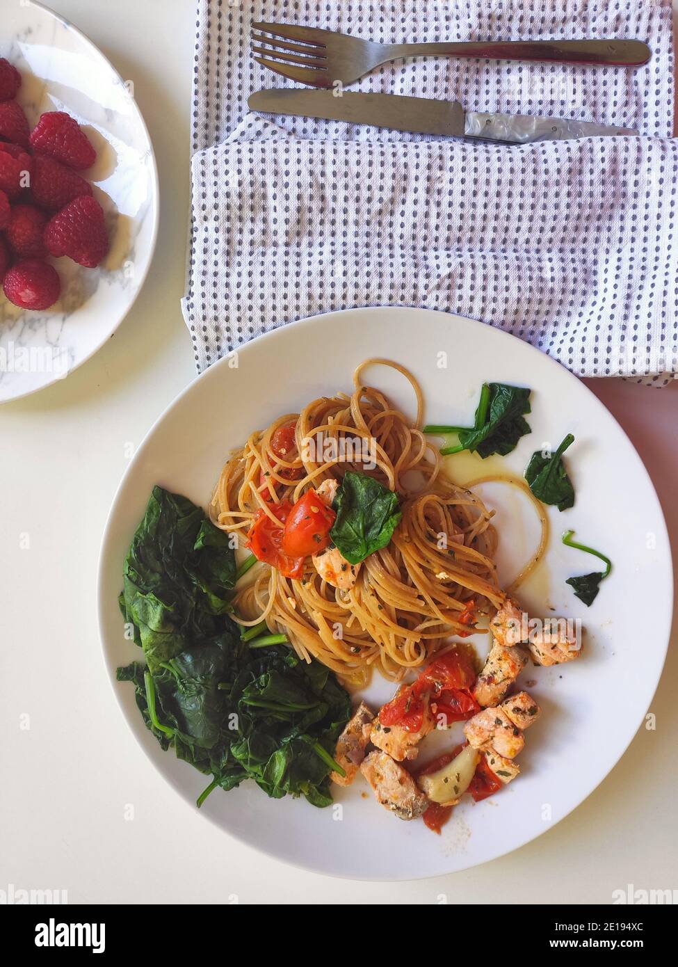 Spaghetti mit Spinat und Lachs in einer weißen Schüssel Stockfoto