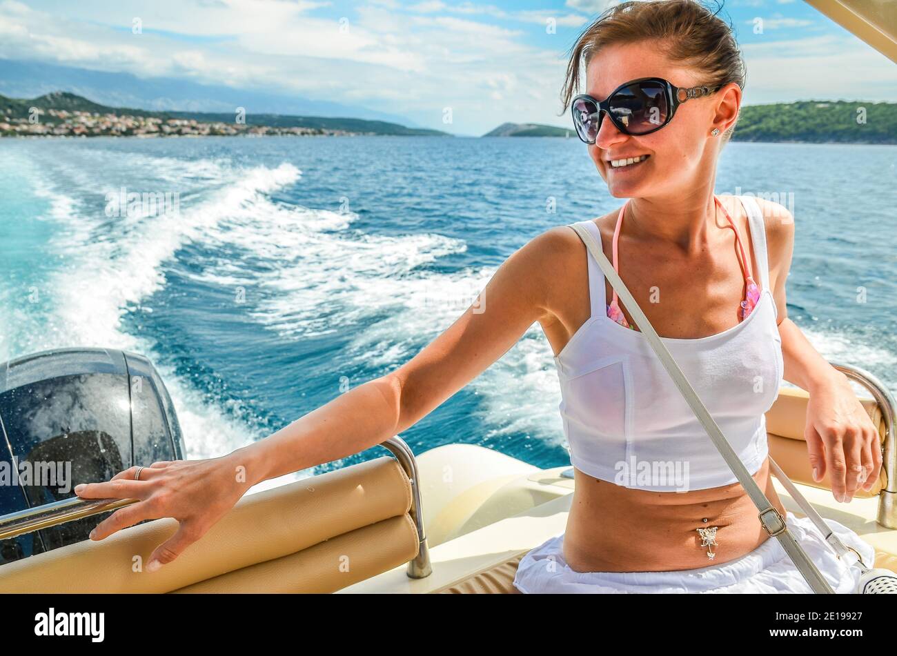 Junge Frau in Sonnenbrillen auf dem Motorboot, auf der adria im Urlaub. Stockfoto