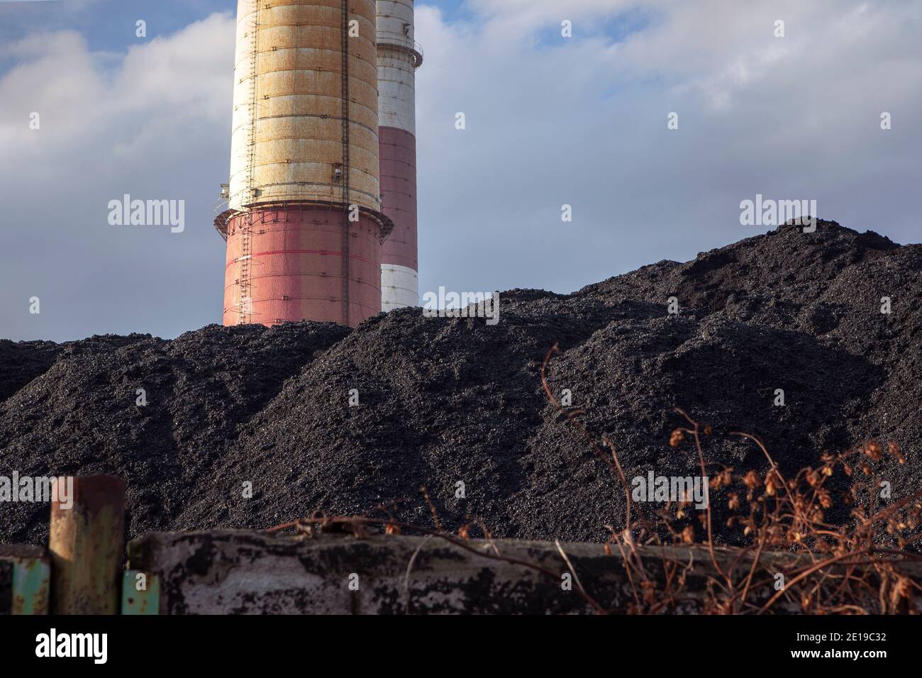 Steinkohlehaufen, natürliche Steinkohle mit Industriekamin. Industrielandschaft. Globale Erwärmung, CO2-Emissionen, Kohlenenergieprobleme. Stockfoto