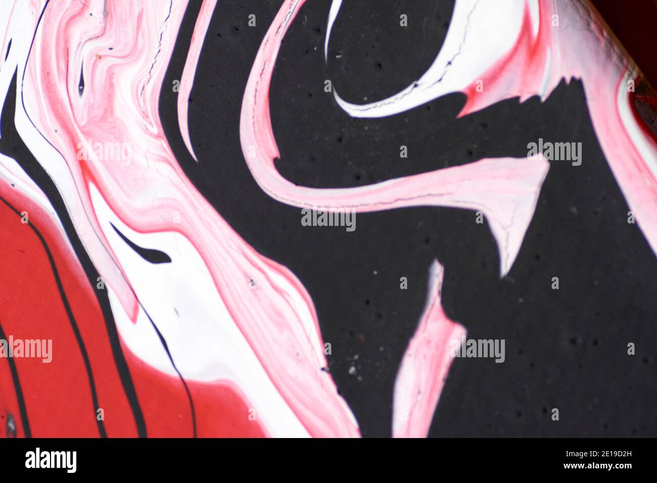 Marmoriertes Acrylfarbenmuster in den Farben rot, schwarz, weiß und pink Stockfoto