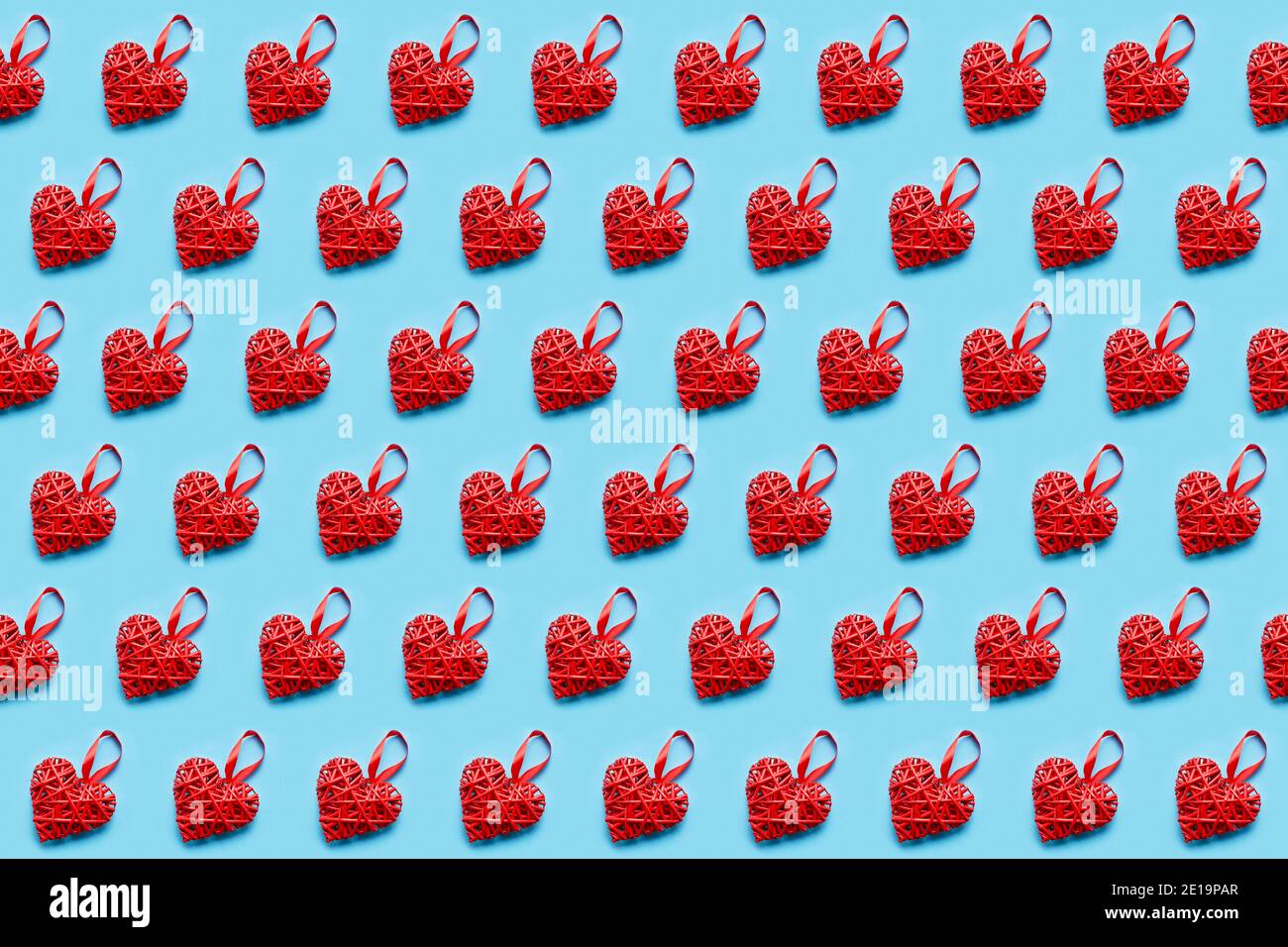 Rotes Korbherz auf blauem Hintergrund. Nahtloses Muster. Valentinstagskonzept, Draufsicht. Stockfoto