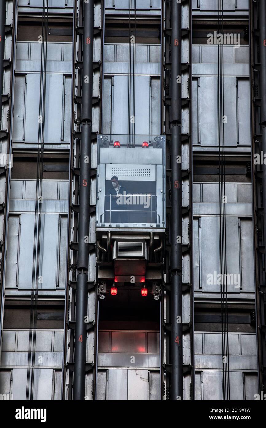 Ein Arbeiter nimmt den Aufzug in Lloyds of London, in der City of London während der Coronavirus Tier 2 Lockdown, Financial District, London, England, Großbritannien Stockfoto