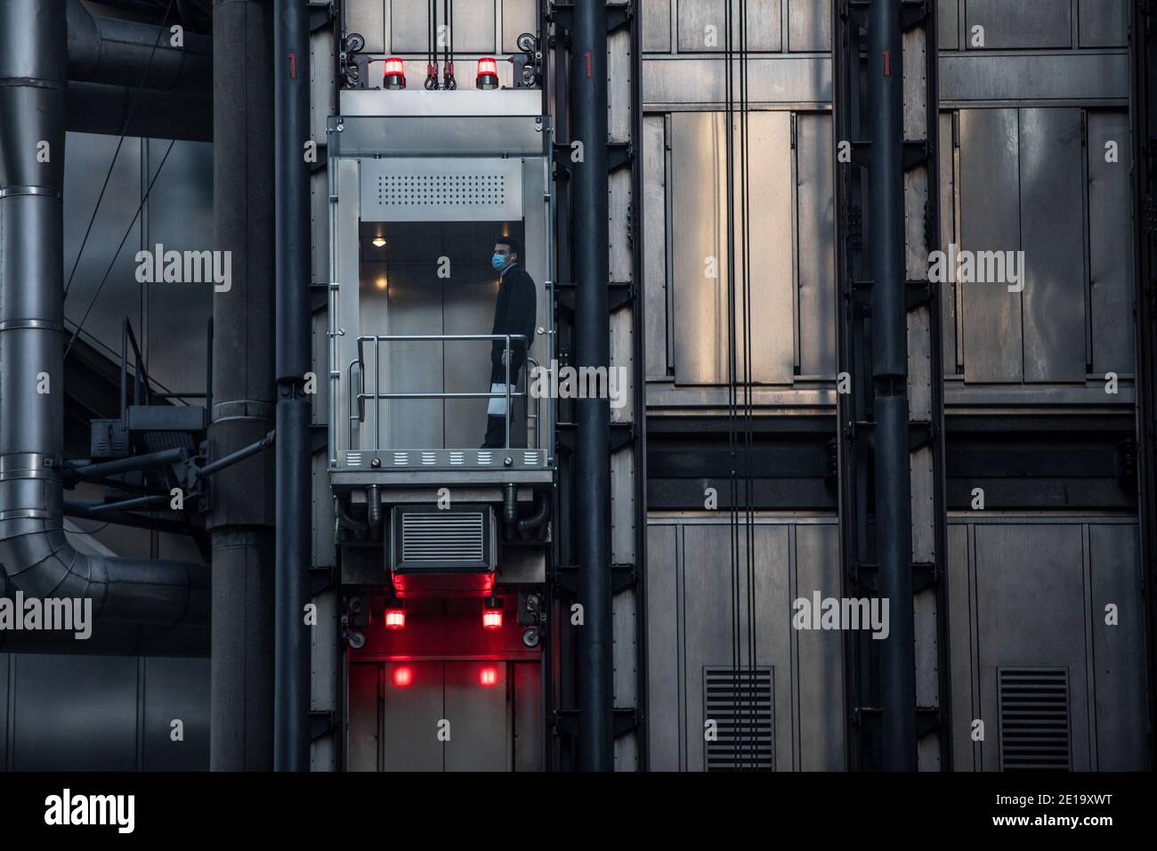 Ein Arbeiter nimmt den Aufzug in Lloyds of London, in der City of London während der Coronavirus Tier 2 Lockdown, Financial District, London, England, Großbritannien Stockfoto