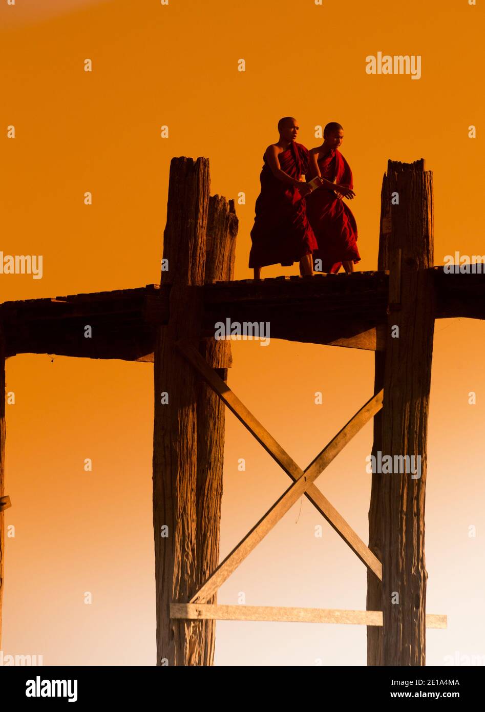 Mönche überqueren U Bein's Bridge bei Sonnenuntergang Stockfoto