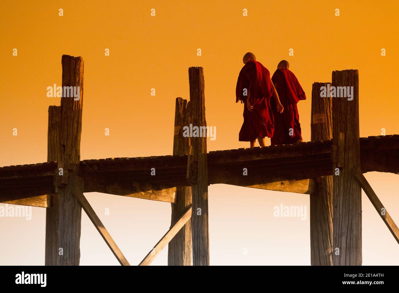 Mönche überqueren U Bein's Bridge bei Sonnenuntergang Stockfoto