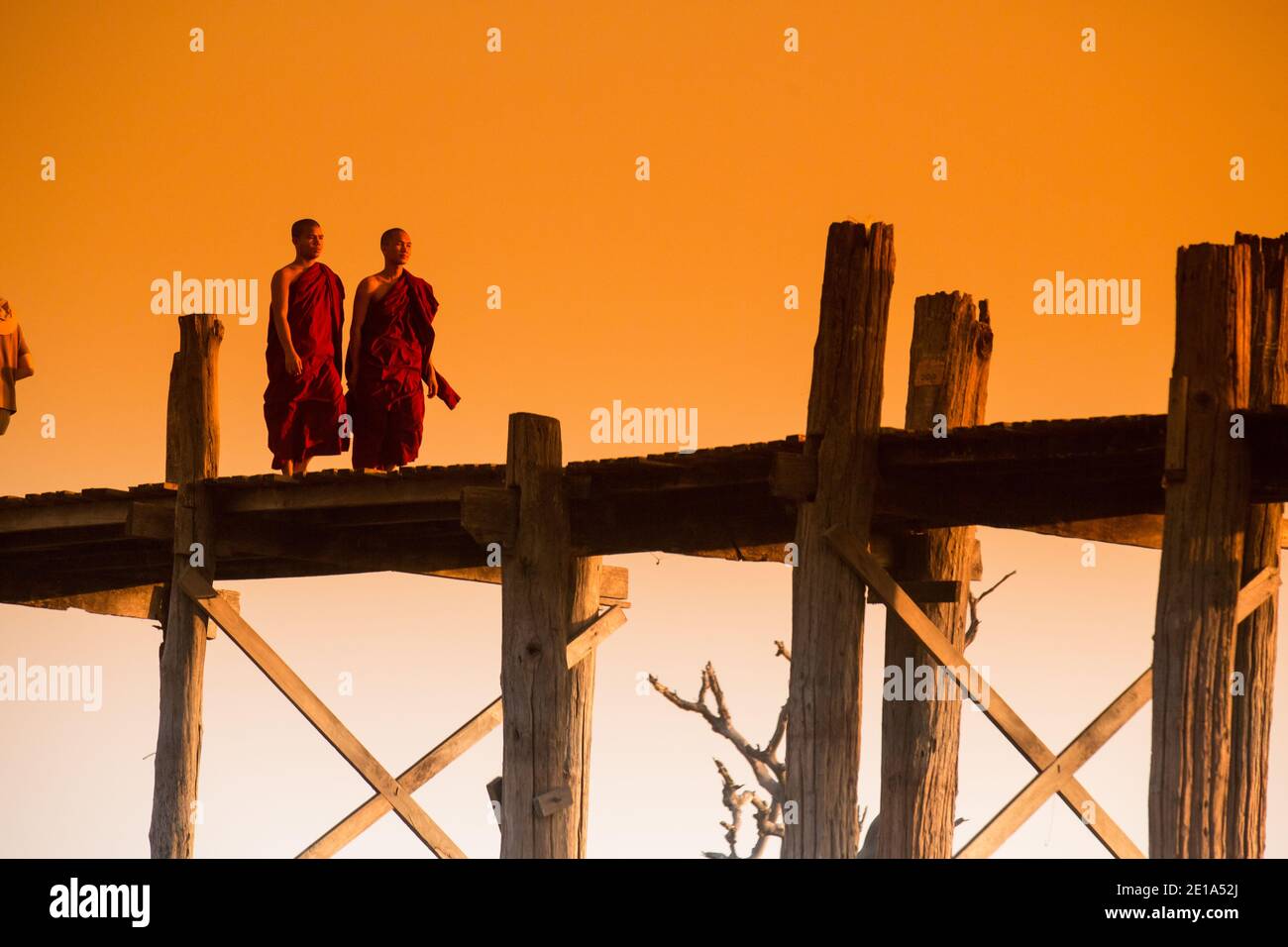 Mönche überqueren U Bein's Bridge bei Sonnenuntergang Stockfoto