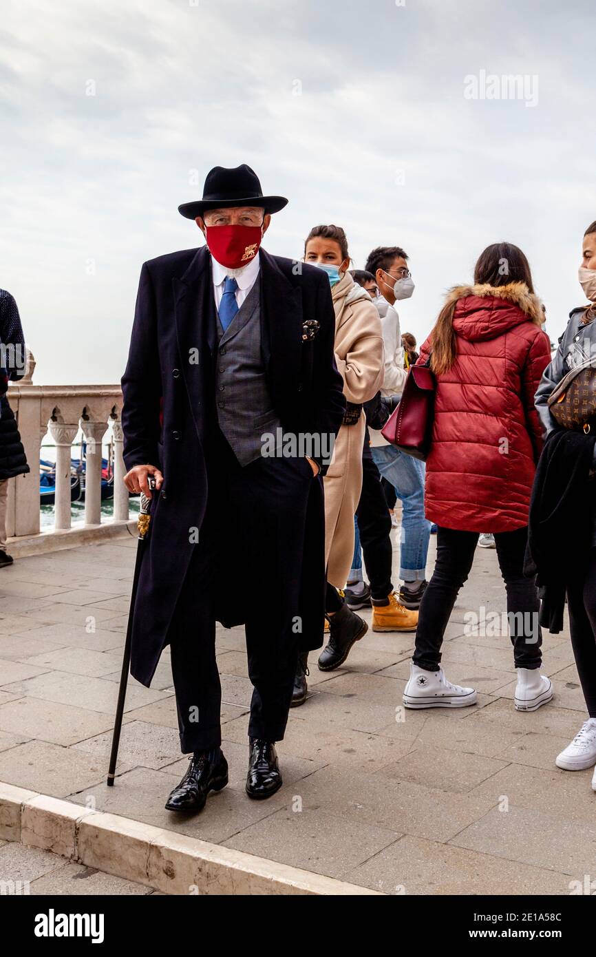 Ein gut gekleideter venezianischer Mann mit GESICHTSMASKE während der Pandemie von Covid 19, Venedig, Italien. Stockfoto