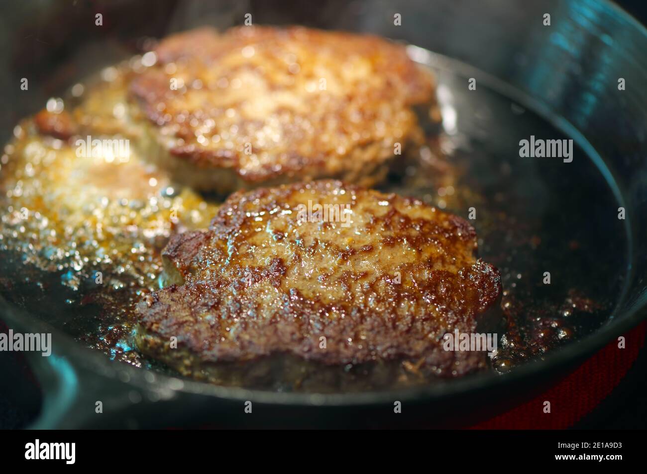 Hamburger Patties Braten in einer Pfanne auf dem Herd. Stockfoto