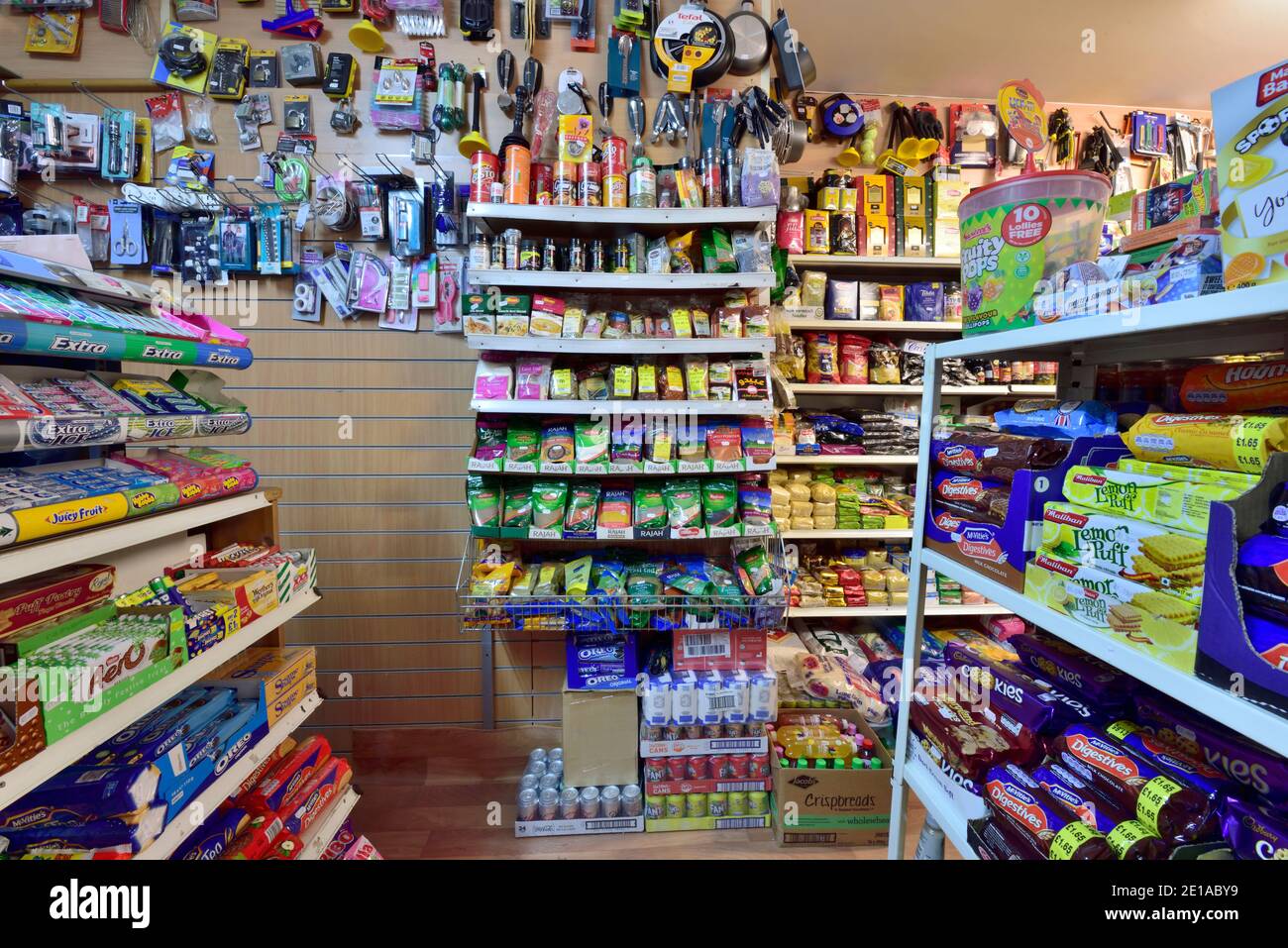 Regale voll von einer breiten Palette von Lebensmitteln, Gewürzen und Haushaltswaren in lokalen kleinen Ecke Shop, Metro Convenience Store, Großbritannien Stockfoto