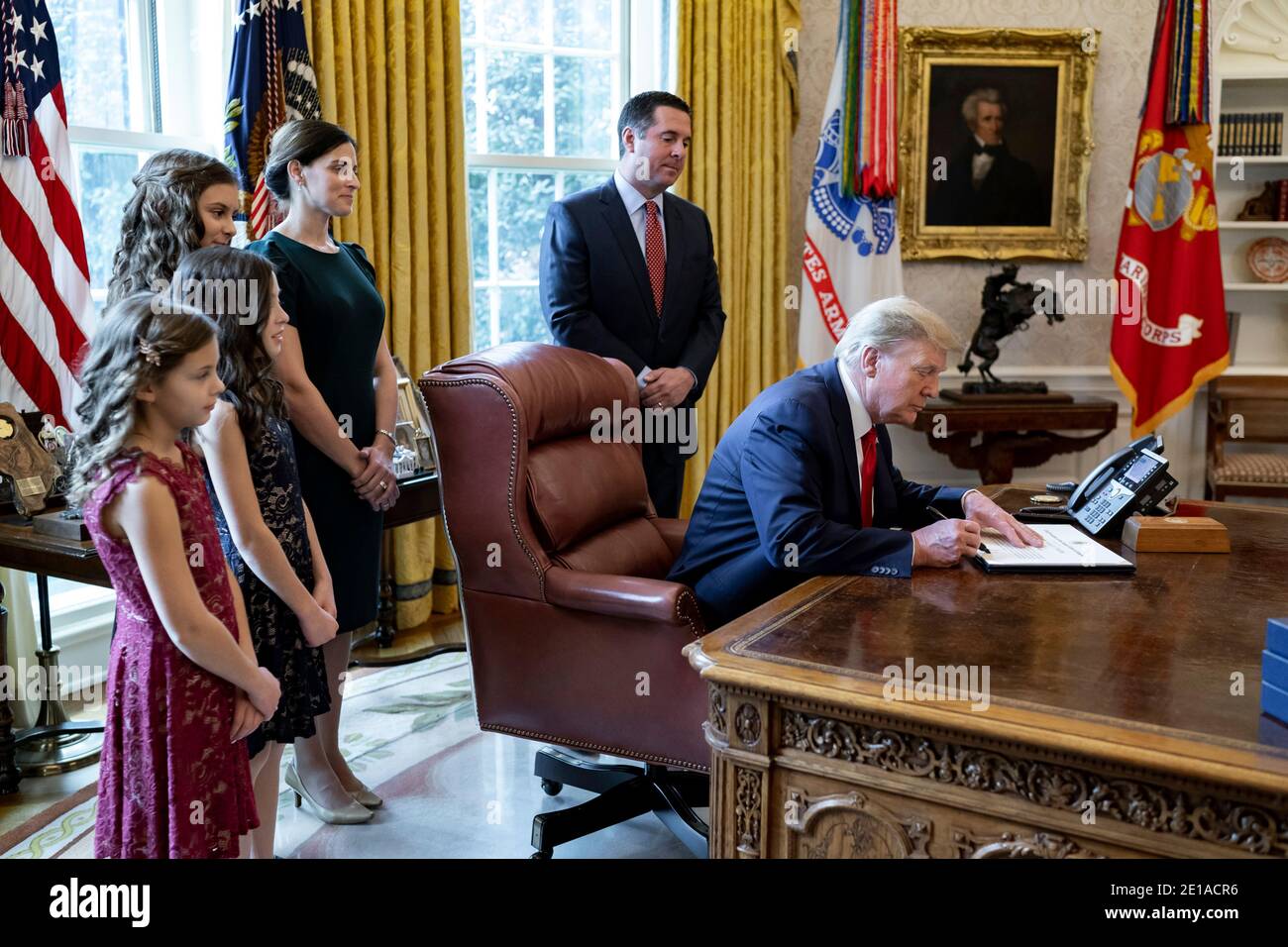 Washington, Vereinigte Staaten Von Amerika. Januar 2021. US-Präsident Donald Trump unterzeichnet die Urkunde als Rep. Devin Nunes, rechts, und Familie schauen nach der Medaille der Freiheit Zeremonie im Oval Office im Weißen Haus 4. Januar 2021 in Washington, DC Kredit: Planetpix/Alamy Live News Stockfoto
