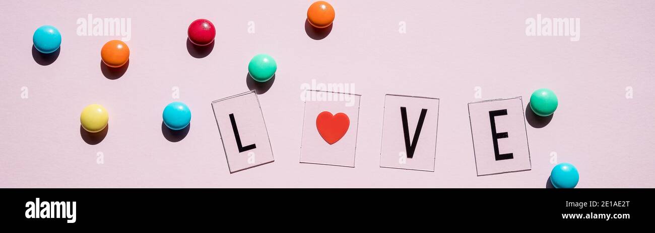 Rosa Bonbons, Lutscher und Jelly Beans auf weißem Holz- Hintergrund. Süße Grußkarte. Kopieren Sie Platz. Ansicht von oben Stockfoto