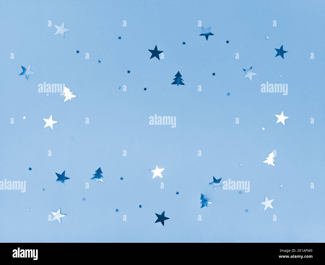 Konfetti Sterne und Bäume funkeln auf blauem Hintergrund. Stockfoto