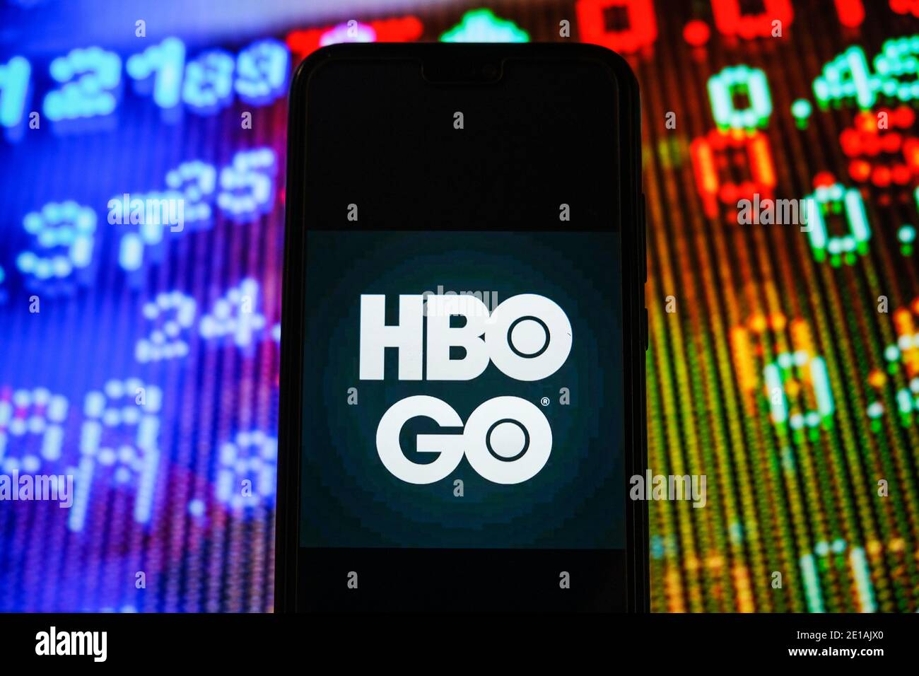 In dieser Abbildung wird ein HBO GO-Logo auf einem Smartphone mit Börsenpreisen im Hintergrund angezeigt. Stockfoto