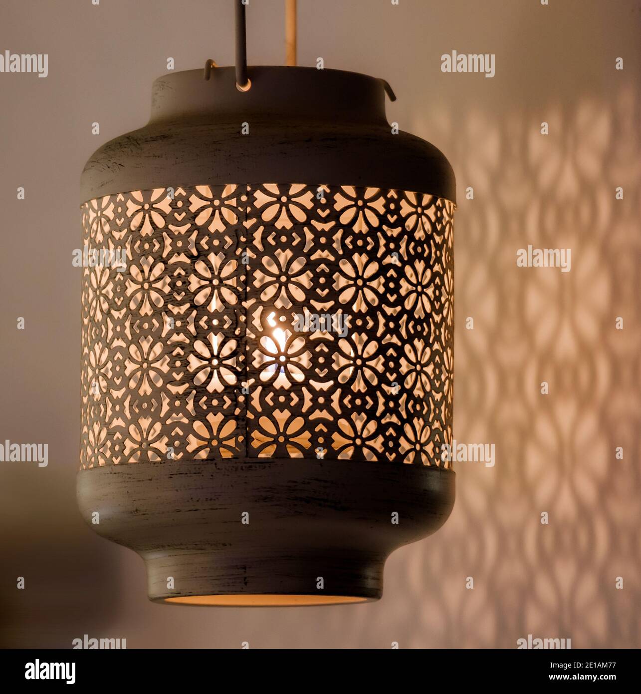 Kerzenlicht Lampe mit schönen detaillierten antiken Mustern Designs Gießen Schatten über der nahen Wand Stockfoto