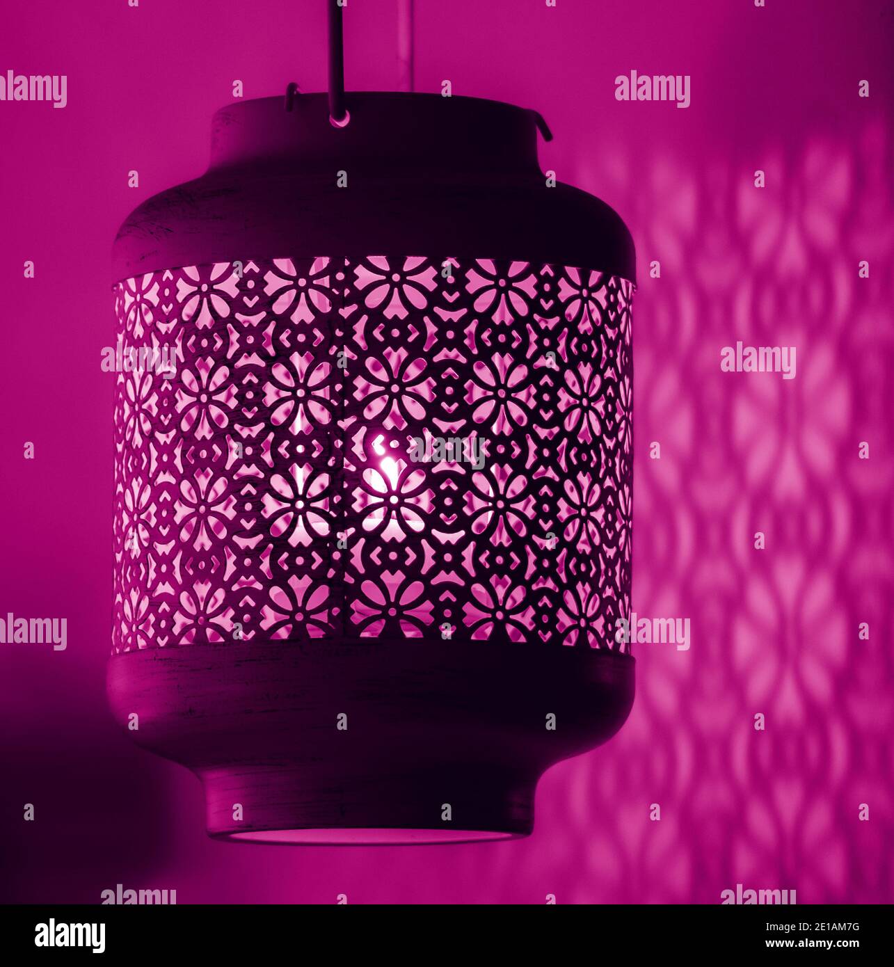 Kerzenlicht Lampe mit schönen detaillierten antiken Mustern Designs Gießen Schatten über der nahen Wand Stockfoto