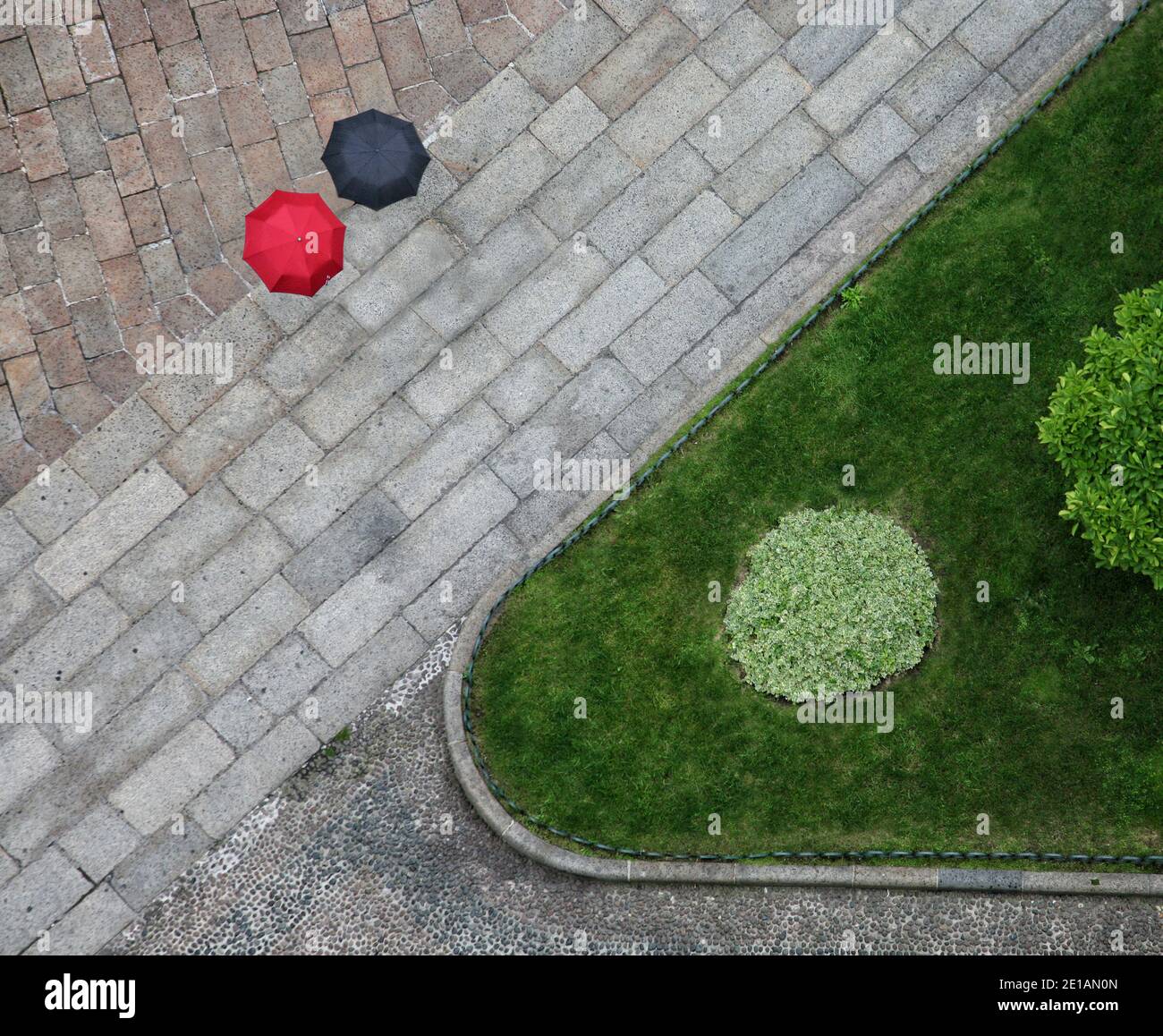 Blick von oben auf die Straßengeometrie mit schwarz und rot Regenschirme Stockfoto