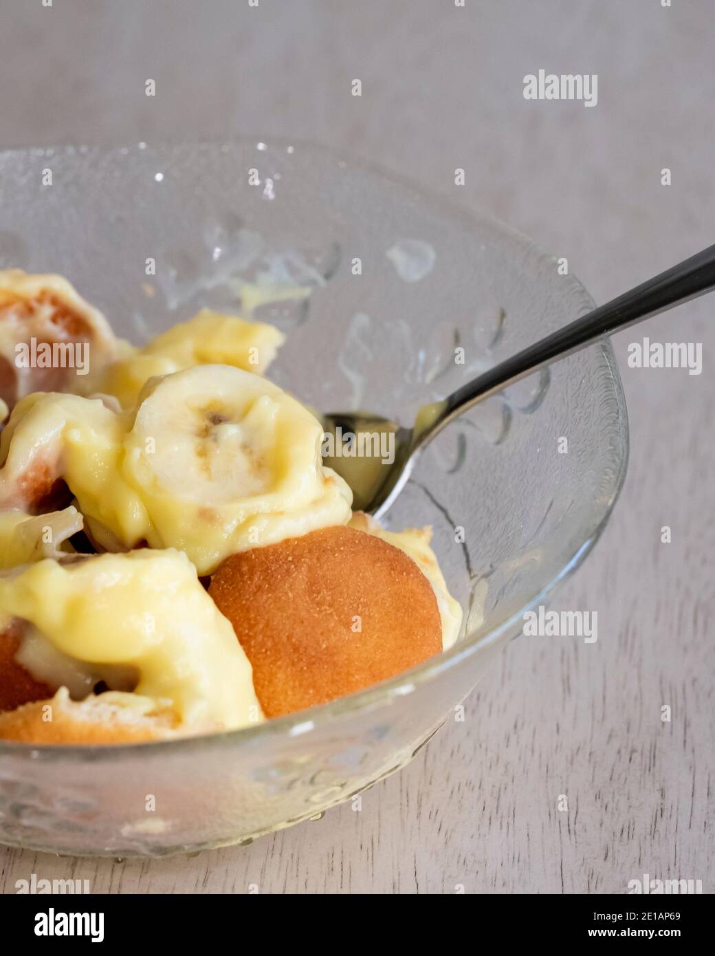 Nahaufnahme einer Portion Bananenpudding mit Pudding, Vanilleplätzchen und in Scheiben geschnittenen Bananen in einer Schüssel mit Löffel serviert. USA. Stockfoto