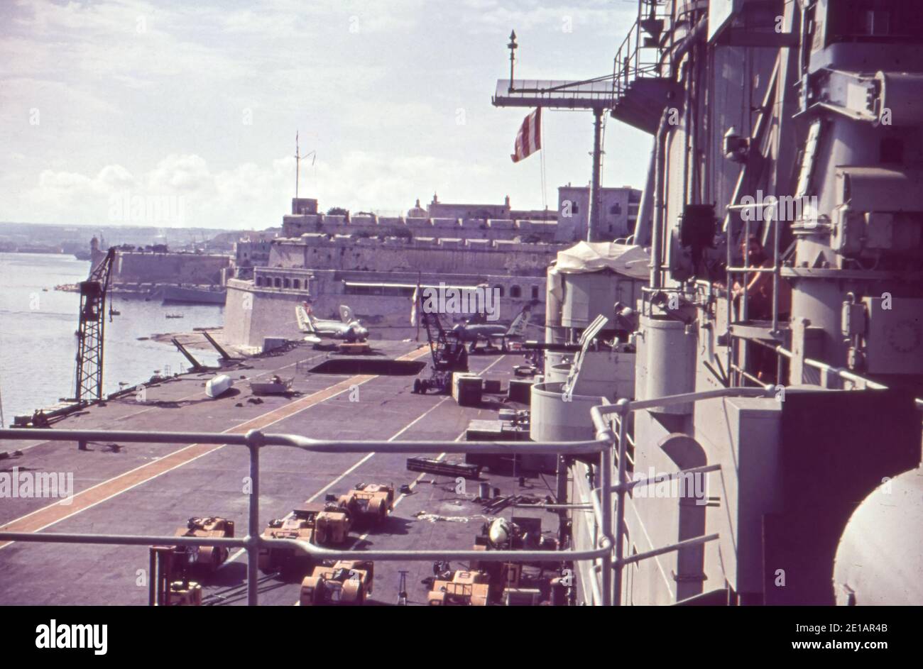 Das Flugdeck der HMS Ark Royal in Valletta Grand Harbour, Valletta, Malta. Auf dem Deck befinden sich zwei Supermarine Scimitar-Kampfjets des NAS. Ein Mitglied der Crew schaut aus dem Überbau. November 1960. Stockfoto