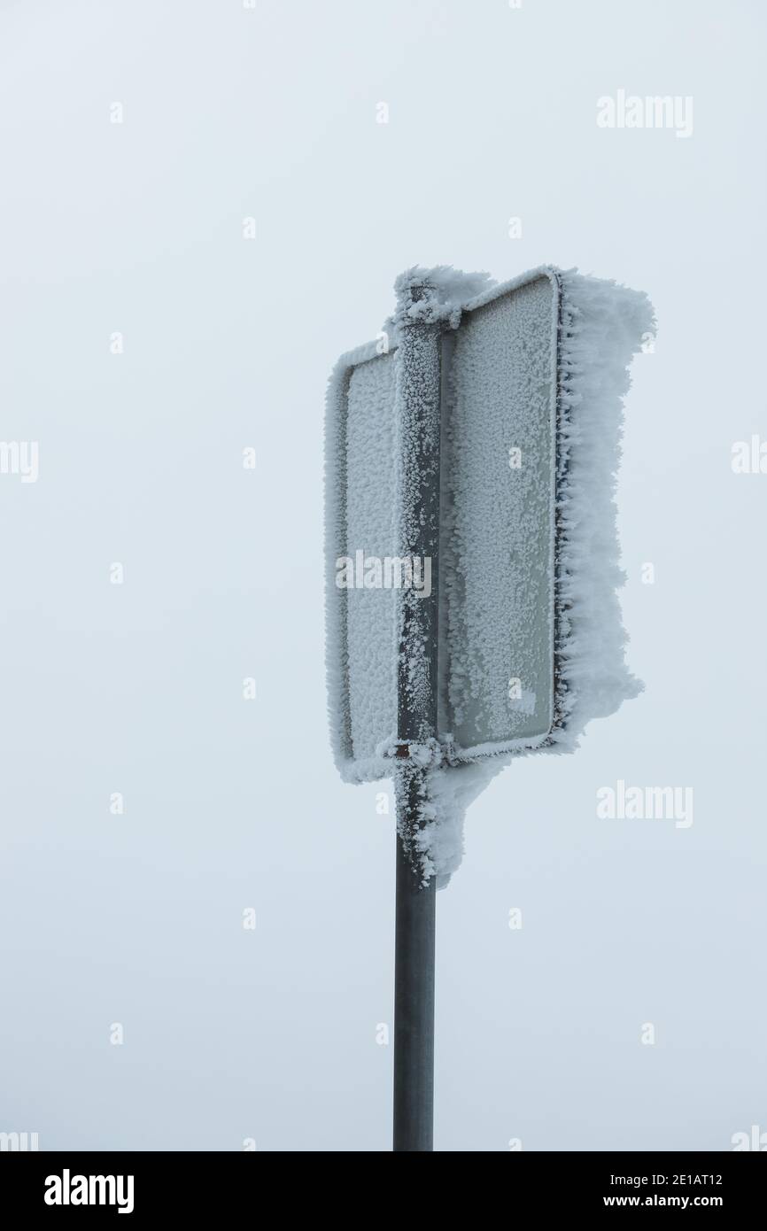 Isoliertes gefrorenes Verkehrsschild an einem nebligen Morgen Stockfoto