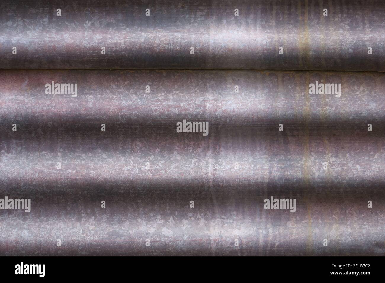 Metallhintergrundstruktur Nahaufnahme mit abstrakten Linien und einer melierten, rostigen Oberfläche. Stockfoto