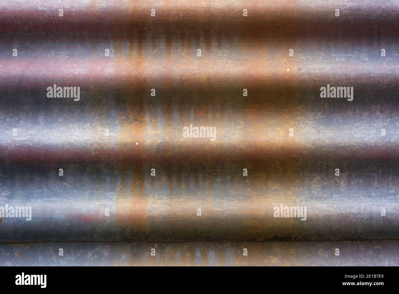 Metallhintergrundstruktur Nahaufnahme mit abstrakten Linien und einer melierten, rostigen Oberfläche. Stockfoto