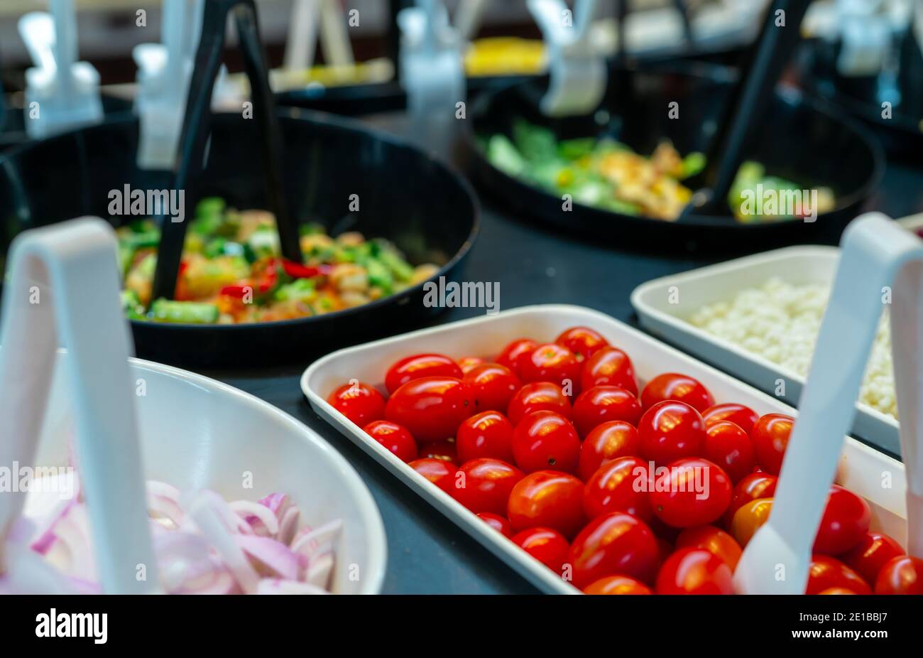 Salatbuffet im Restaurant. Frisches Salatbuffet zum Mittag- oder Abendessen. Gesunde Ernährung. Selektive Konzentration auf rote Tomaten in weißer Schüssel auf der Theke. Stockfoto