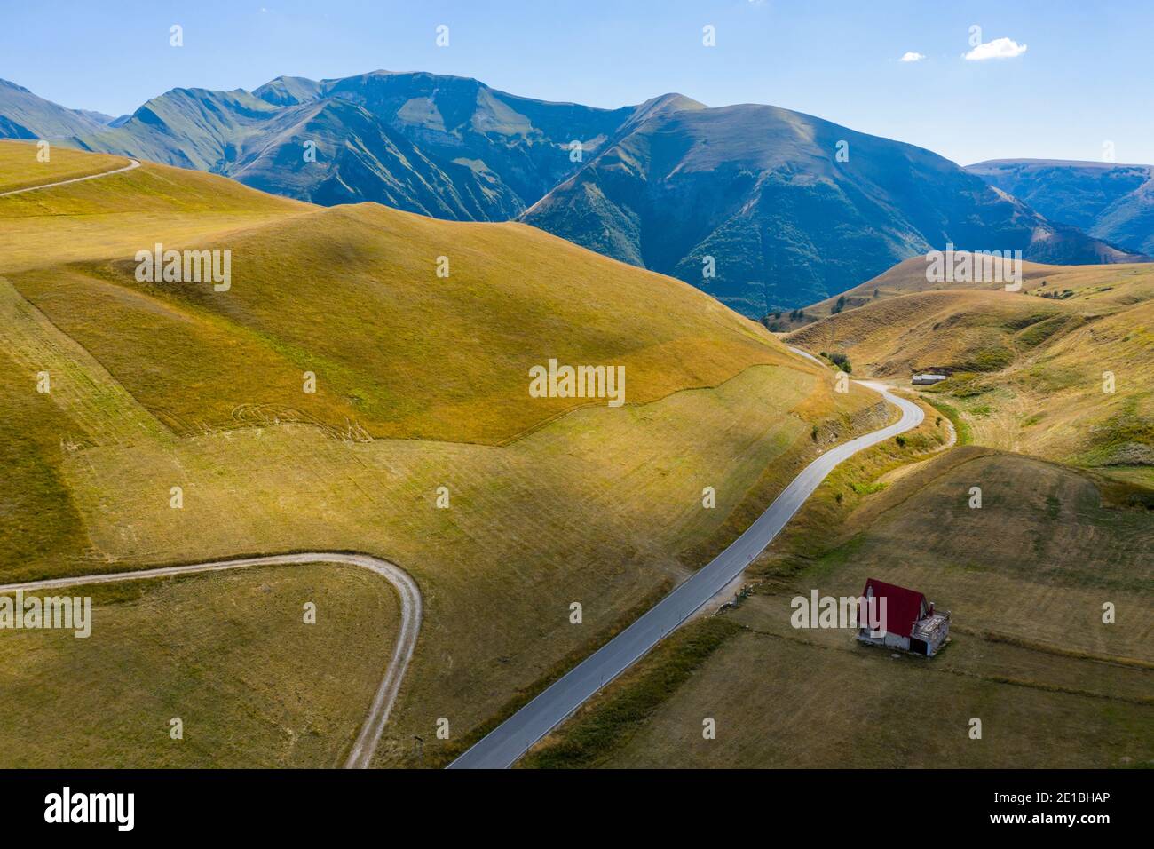 Isoliertes Bergchalet in den italienischen Sibillini Bergen. Wunderbare Weide mit gelbem Gras. Valico S. Maria Maddalena, Appenninen Stockfoto