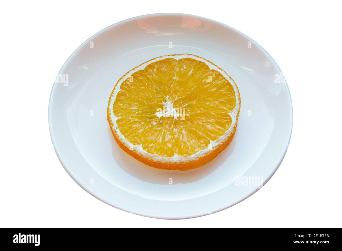 Platte mit einer Scheibe getrocknetes Orange isoliert auf weißem Hintergrund. Stockfoto