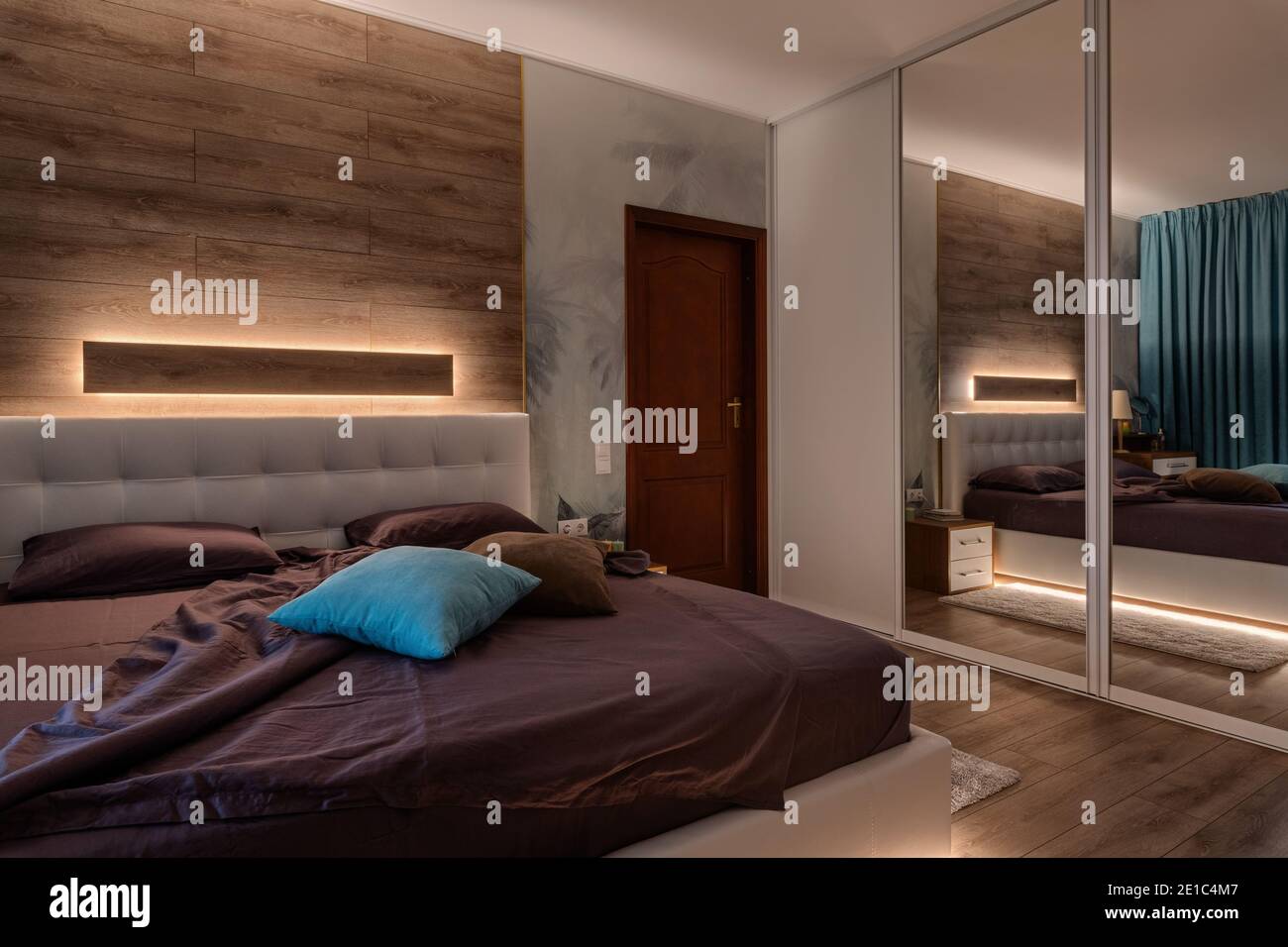 Gemütliches, modernes Schlafzimmer mit dekorativen Lichtern Stockfoto