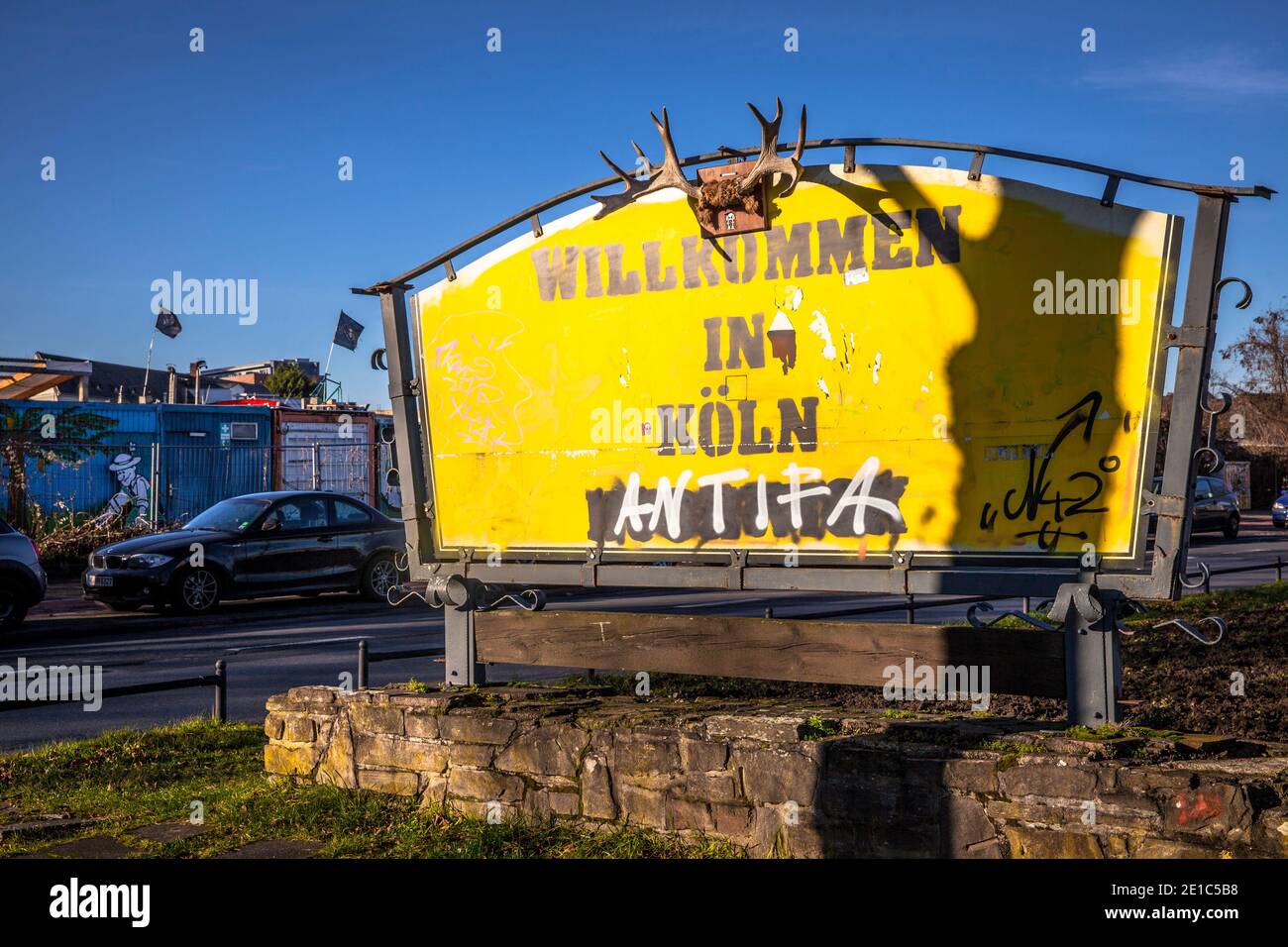 Das Zeichen eines ehemaligen Gasthauses wurde in ein ungewöhnliches Stadteingangsschild mit Geweih verwandelt, Übersetzung: Willkommen in Köln, Alteburger Straße, Köln, Stockfoto