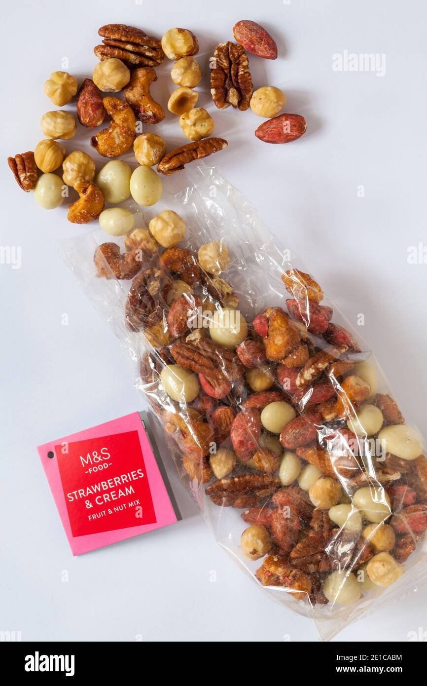 Packung mit M&S Erdbeeren & Sahne Obst & Nuss Mix Geöffnet mit verschüttetem Inhalt, der isoliert auf weißem Hintergrund verschüttet wurde Stockfoto