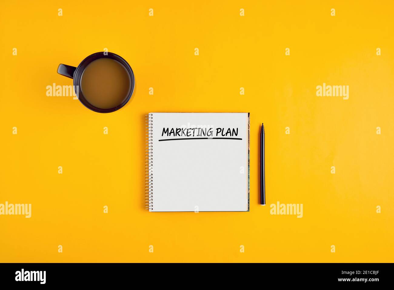 Das Wort Marketing Plan geschrieben auf Notebook mit Stift und Kaffeebecher auf gelbem Hintergrund. Stockfoto