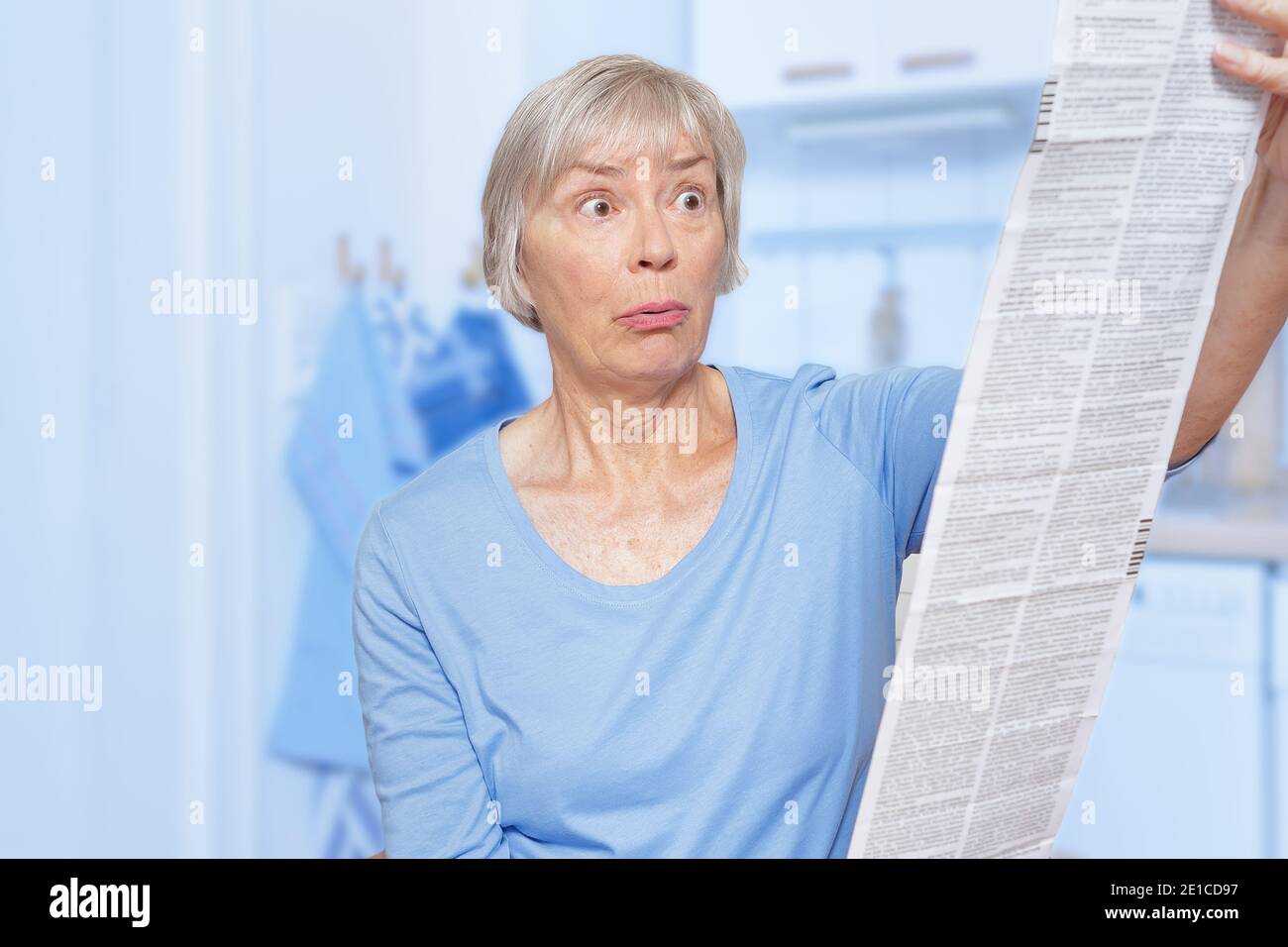 Schockierte ältere Frau mit einem riesigen Patienten-Informationsblatt für ihre verordnete Medizin. Stockfoto