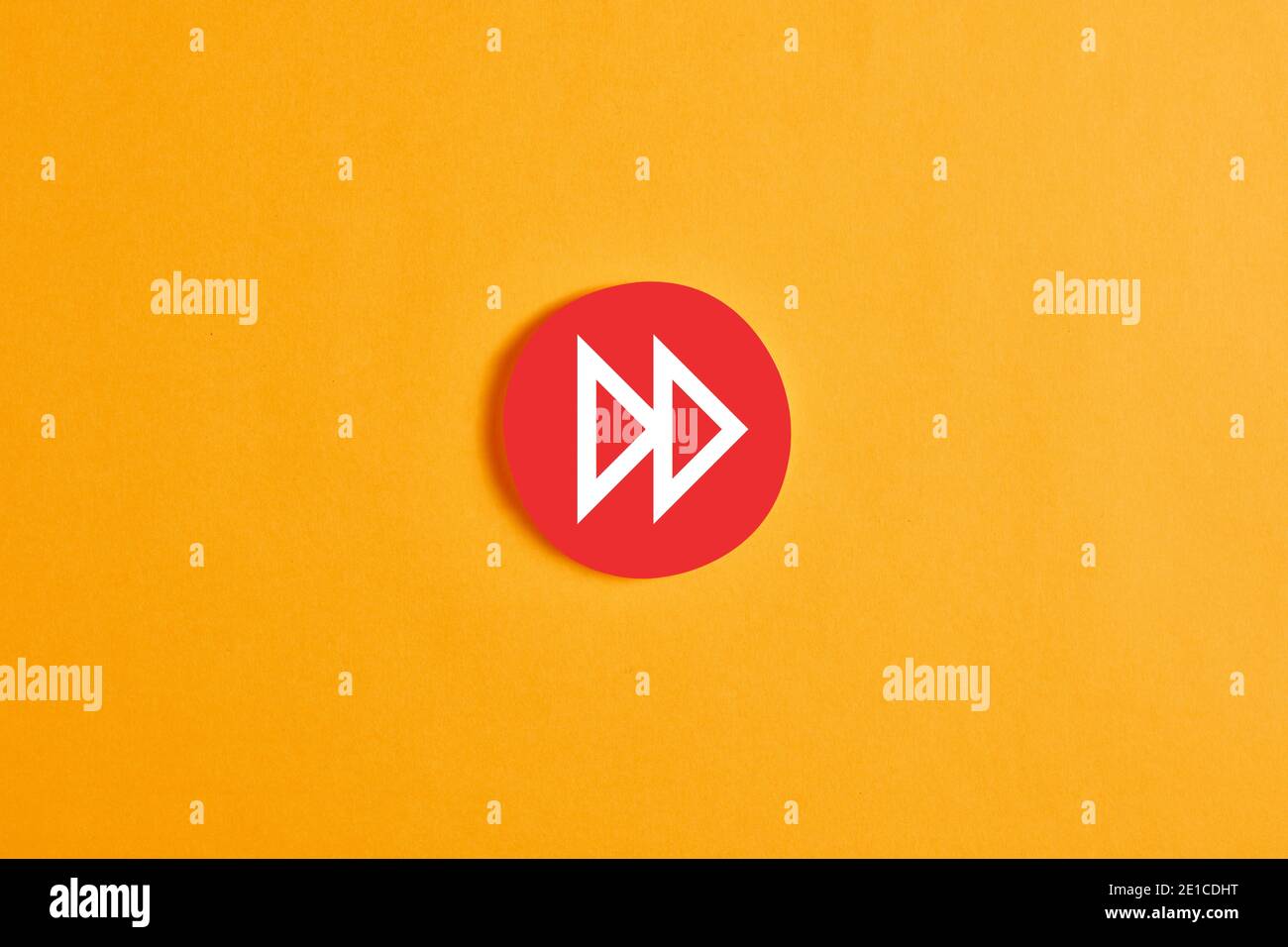 Roter runder Kreis mit Schnellvorlauf-Taste oder -Symbol vor gelbem Hintergrund. Stockfoto