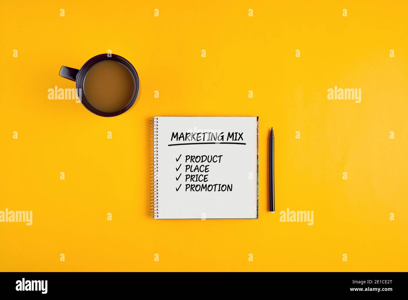 Das Wort Marketing-Mix auf Notizbuch mit Stift und Kaffeetasse auf gelbem Hintergrund geschrieben. Stockfoto