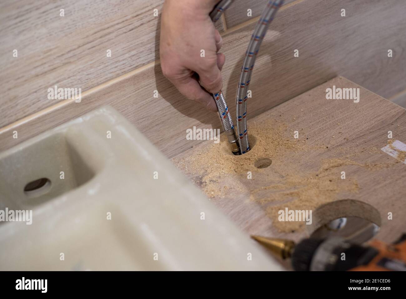 Installieren eines Waschbecken im Badezimmer auf einer hölzernen Arbeitsplatte. Sanitäranlagen. Stockfoto